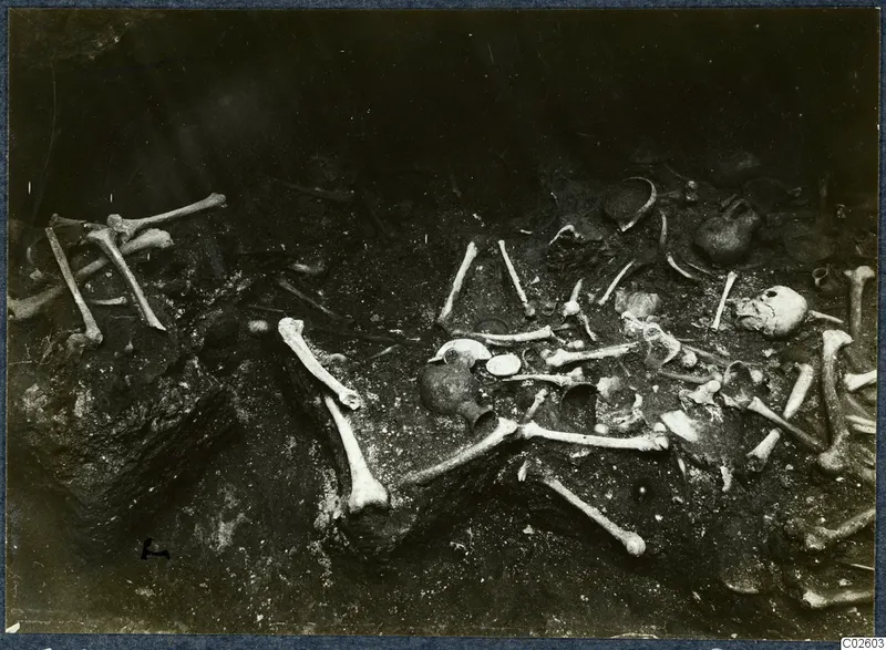 Tomb 6 at Enkomi during excavation, with scattered skeletal remains and small finds in the tomb chamber