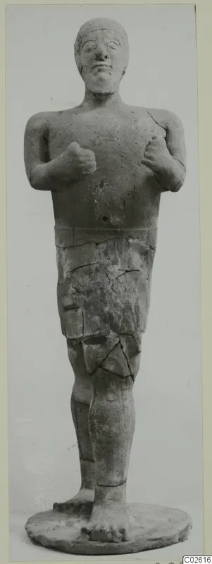 Terracotta standing figure with raised fists and a short skirt, Proto-Cypriote I, shown full length