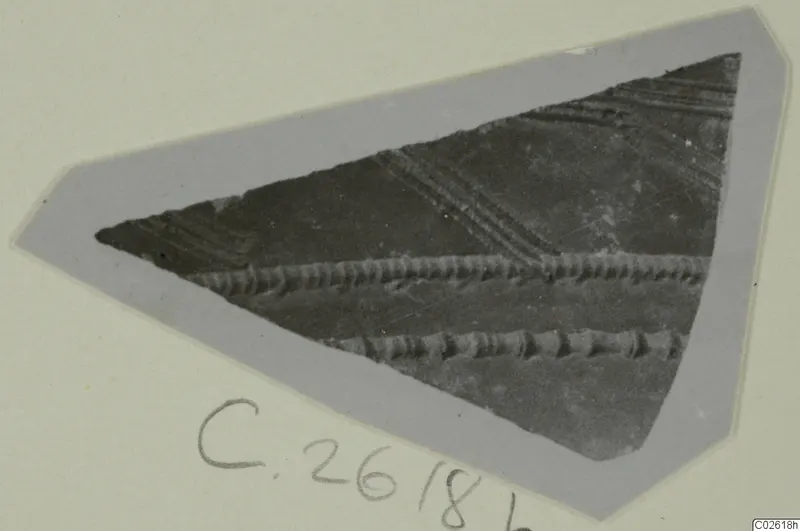 Triangular pottery sherd with horizontal ridged bands and diagonal grooves, shown on a grey card mount