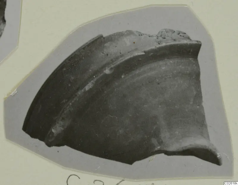 Pottery sherd, a curved rim fragment with a raised band, mounted on grey card