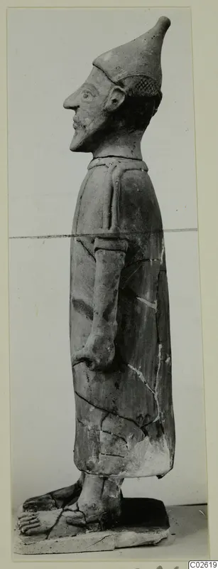Terracotta Proto-Cypriote I: standing figure in profile, facing left, with a tall pointed cap and long garment