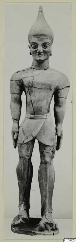 Standing terracotta male figure with a conical headdress, large eyes and a belt, on a rectangular base