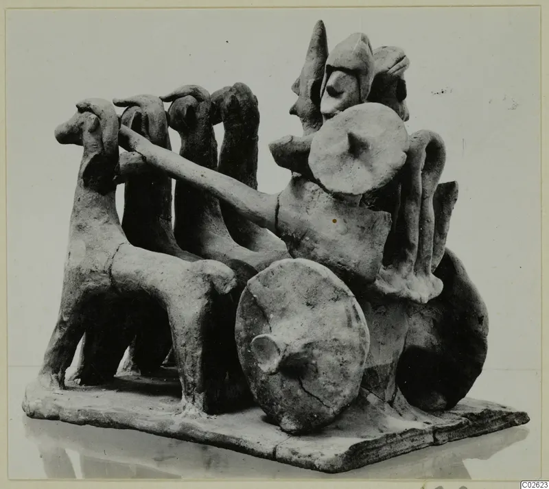 Terracotta model of a chariot drawn by a team of horses, with a standing driver holding the reins, on a flat base.