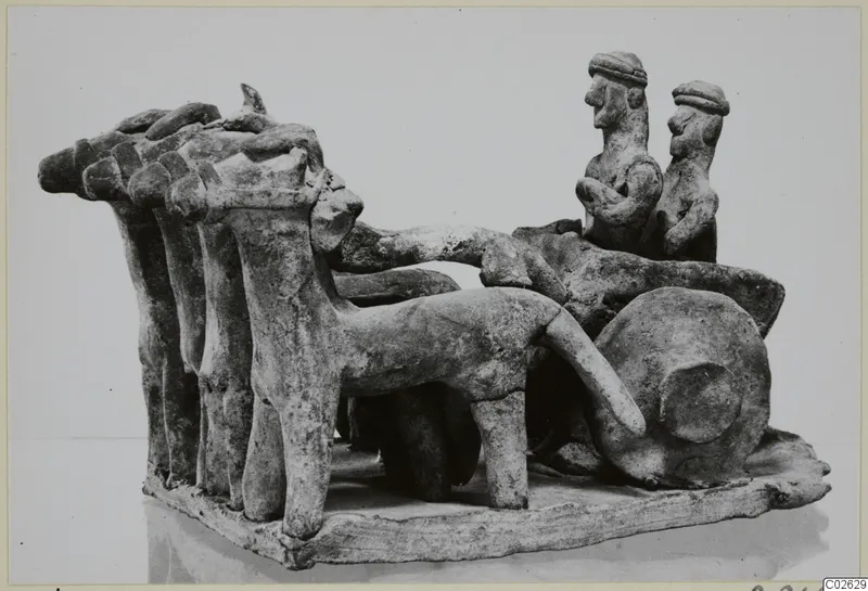 Terracotta model of a wheeled vehicle drawn by a row of animals, with two seated figures, from Ayia Irini