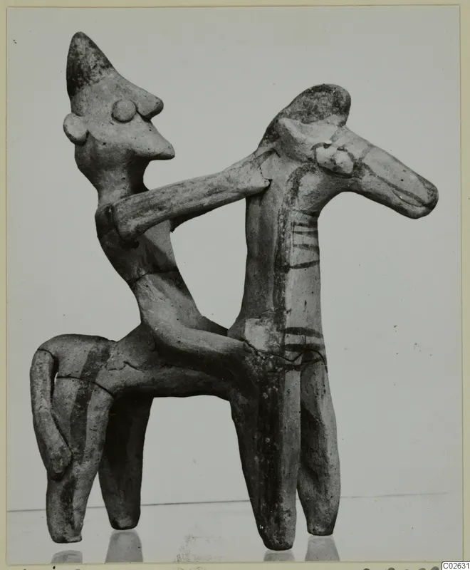 Terracotta figurine of a figure riding a four-legged animal, one arm around its neck, with dark painted stripes.