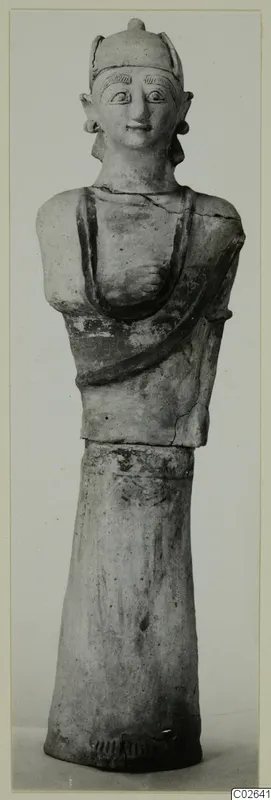 Terracotta statue of a standing figure with a tall headdress, photographed full length against a plain background