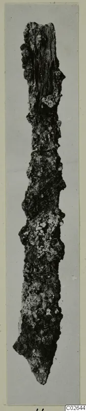 Heavily corroded metal tool from Marion, long and narrow with a pointed end, on a grey mount.
