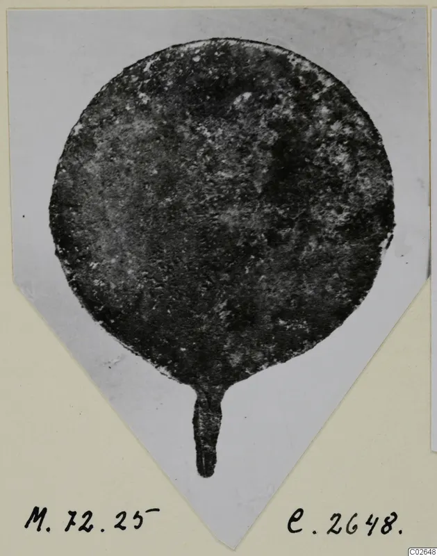 Bronze toilet requisite: a round disc with a short stem, corroded, photographed on a mounted card