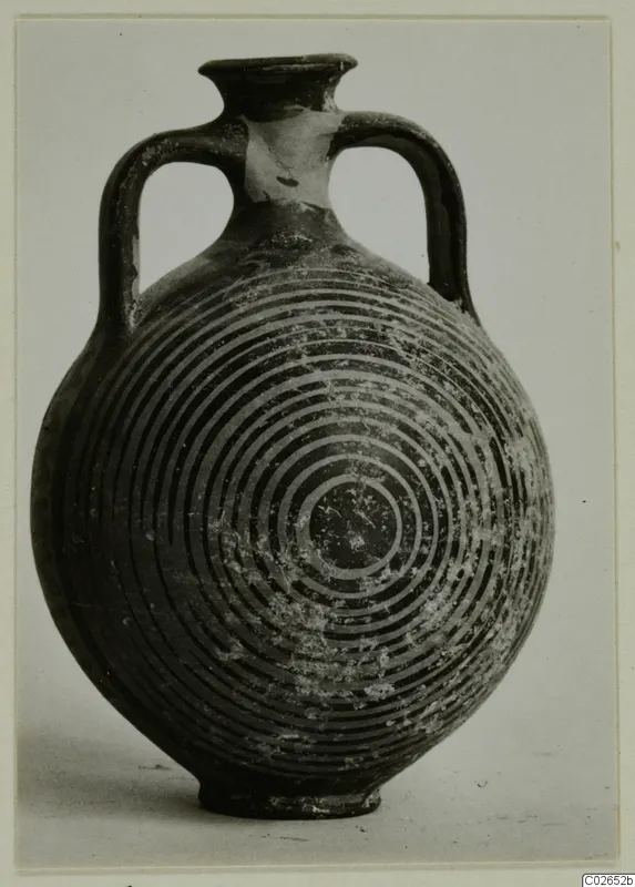 Two-handled vessel with a rounded body and concentric ring decoration, photographed against a plain grey background