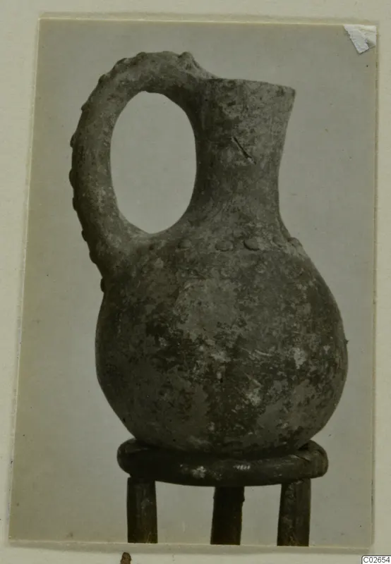Pottery jug with a loop handle and narrow neck, from Ayios Iakovos, shown on a wooden stand
