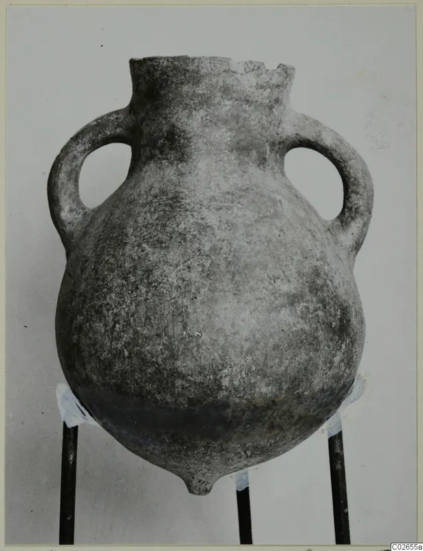 Two-handled pottery vessel with a rounded body and broken rim, photographed upright on a three-legged stand