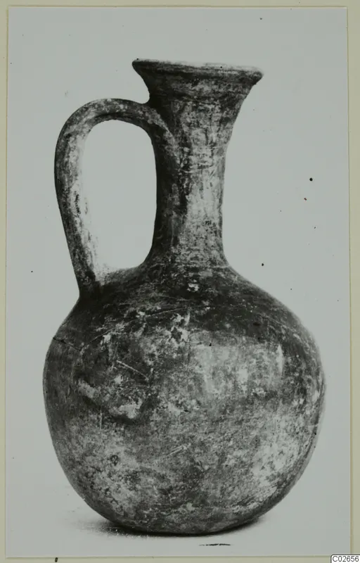 Black Lustrous Ware jug from Ayios Iakovos with a single loop handle and flaring mouth