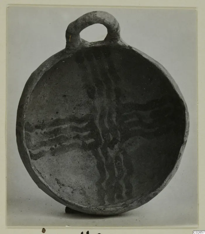 Round shallow vessel with a loop handle at the rim, its interior decorated with wavy dark painted bands