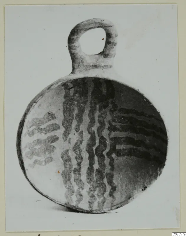 Pottery White Painted IV-V: a round vessel with a loop handle and dark wavy painted bands, from Ayios Iakovos