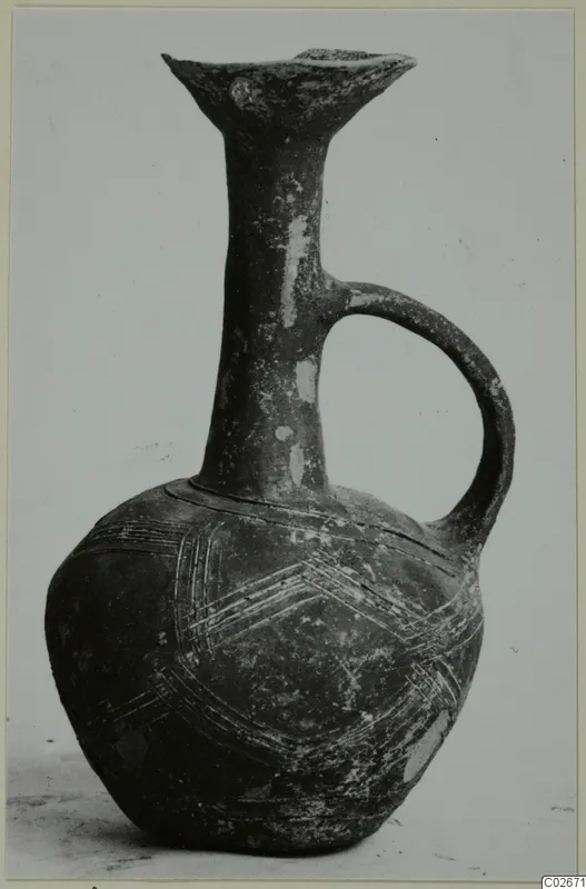 Jug of Black Slip Ware from Ayios Iakovos with a flaring rim, loop handle and incised chevron bands