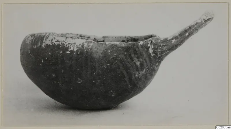 Pottery Red-on-Black etc bowl with a long tapering handle, seen from the side
