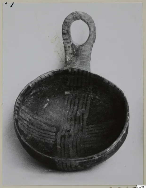 Shallow bowl with a vertical loop handle, its interior decorated with criss-cross bands of dark lines