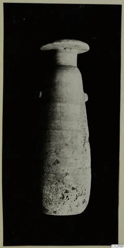 Tall pale stone vase with a wide flat rim and small side lugs, photographed against a black background