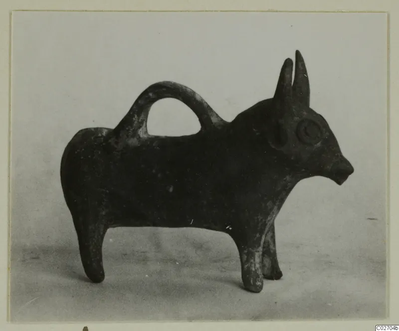 Small dark pottery vessel shaped as a standing bull, with a loop handle over its back, from Ayios Iakovos
