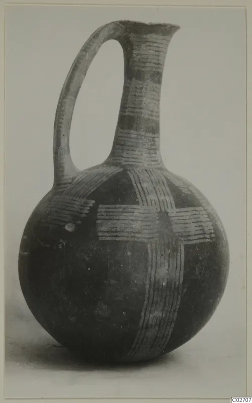 Jug with a rounded body, tall neck and strap handle, decorated with light parallel-line bands on a dark surface