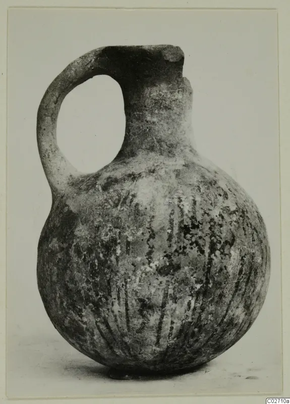 White Painted juglet with a single loop handle and vertical painted lines on its rounded body