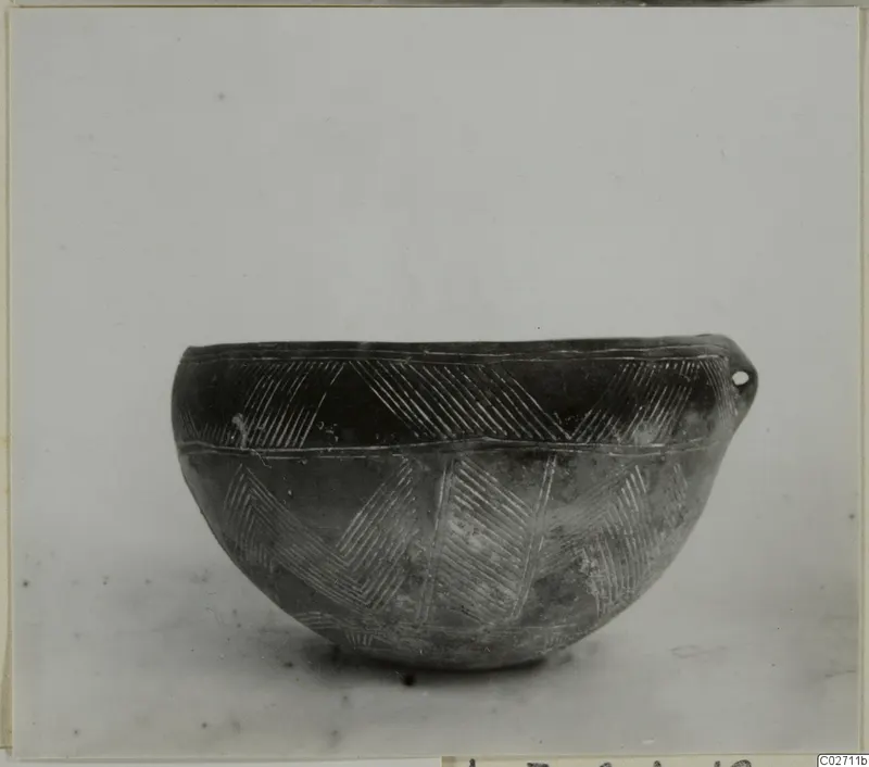 Red Polished III bowl with incised chevron bands and a small pierced lug on the rim