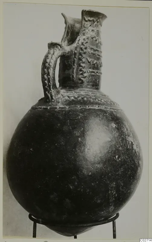 Pottery jug with a strap handle and applied wavy and dotted bands, from the Vrysi tou Barba tombs at Lapithos