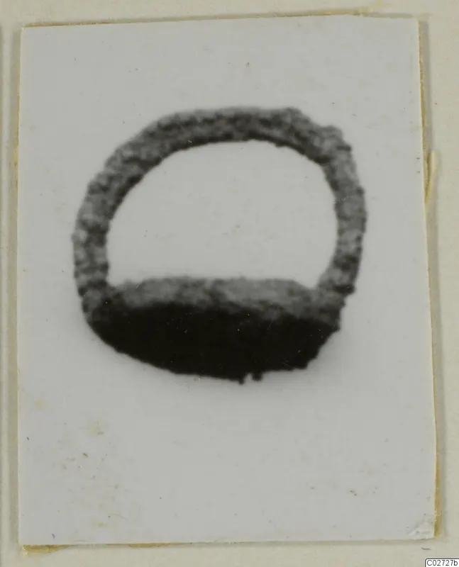 Ring-shaped silver find with a round hoop open at the top, photographed on a white card mount.