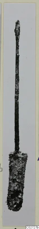 Corroded metal implement with a long thin shaft and a broader, flattened lower end, shown upright on a grey background.