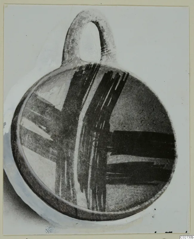 Pottery White Painted IV-V bowl with a loop handle and dark brushed bands, shown on a mounted photograph