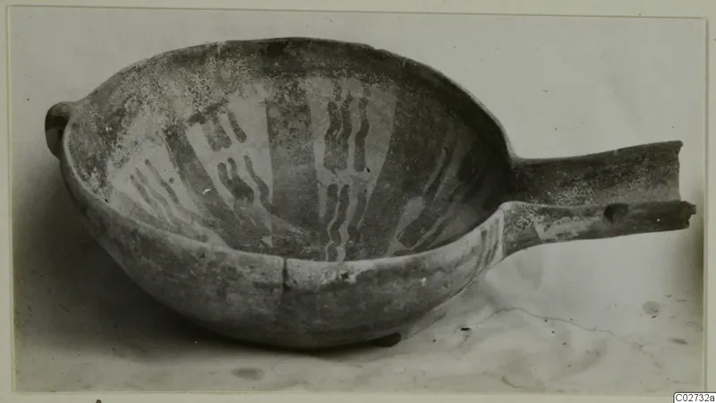 Red-on-Black bowl from Ayios Iakovos with a long horizontal handle and pale painted wavy bands inside