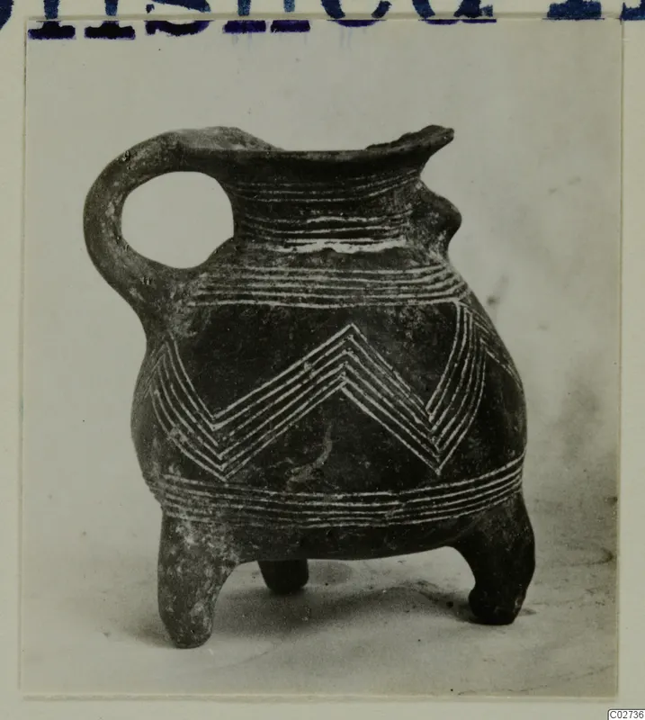 Red Polished III jug from Amathus with three feet, a looped handle and white lined chevron and band decoration