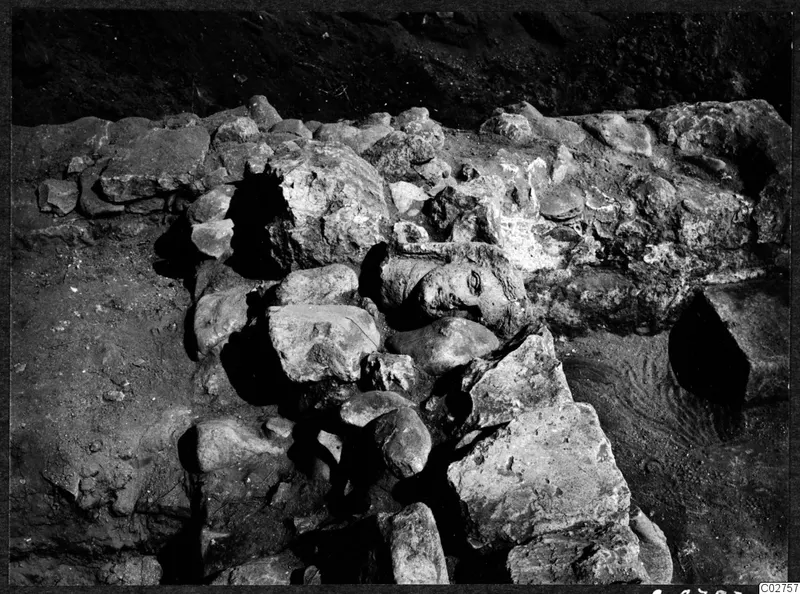 Sculpted head lying half-buried among stones and rubble at Cholades, Soli