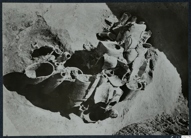 Pit H 14-15 with broken vessels and sherds lying in situ in sandy soil