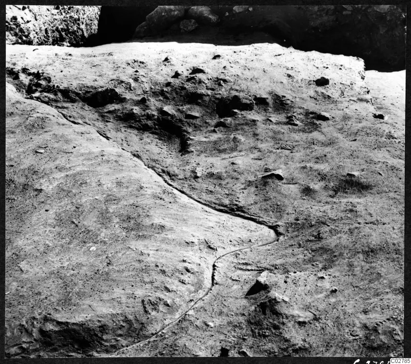 Excavated sand at Mersinaki with the dark curving outline of a pit cut into the natural sand