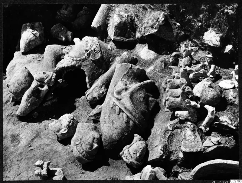 Broken statues and heads lying in excavated soil at Mersinaki, J 18-19