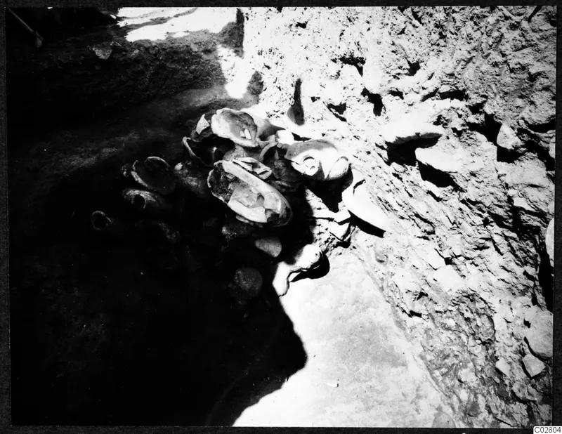 Objects lying in situ in pit G-I 14 at Mersinaki, clustered against an earth face.