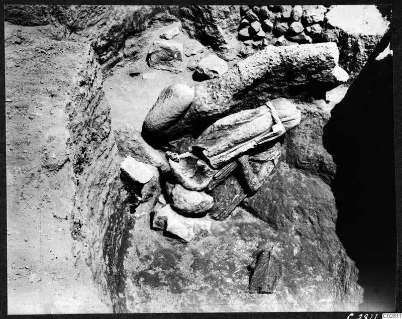 Carved stone fragments lying in situ at Mersinaki in Pit II, among rubble in an excavated pit