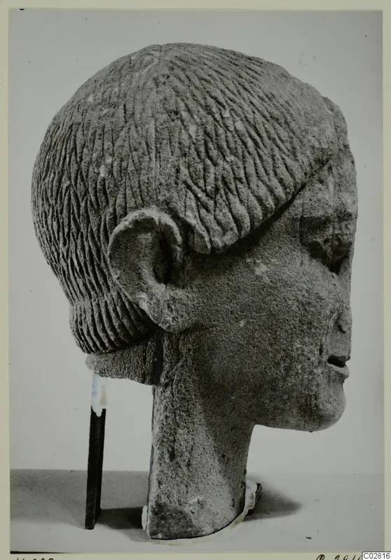 Limestone head from Kition, seen in profile, with incised hair rows and a large ear