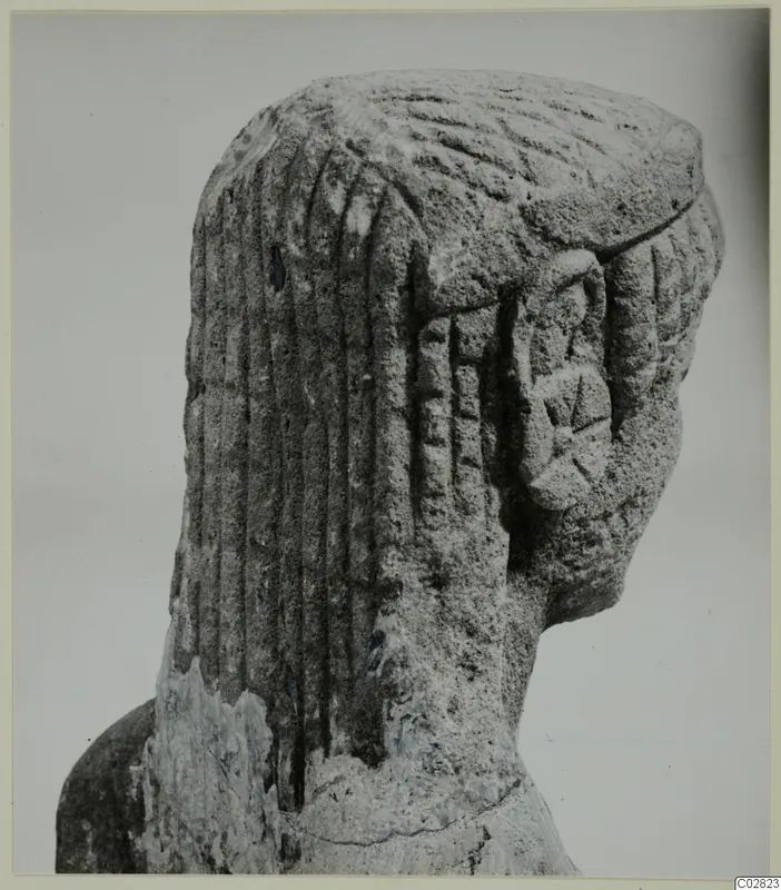Carved limestone head and upper body of a statue from Kition, seen from the side, with grooved hair.