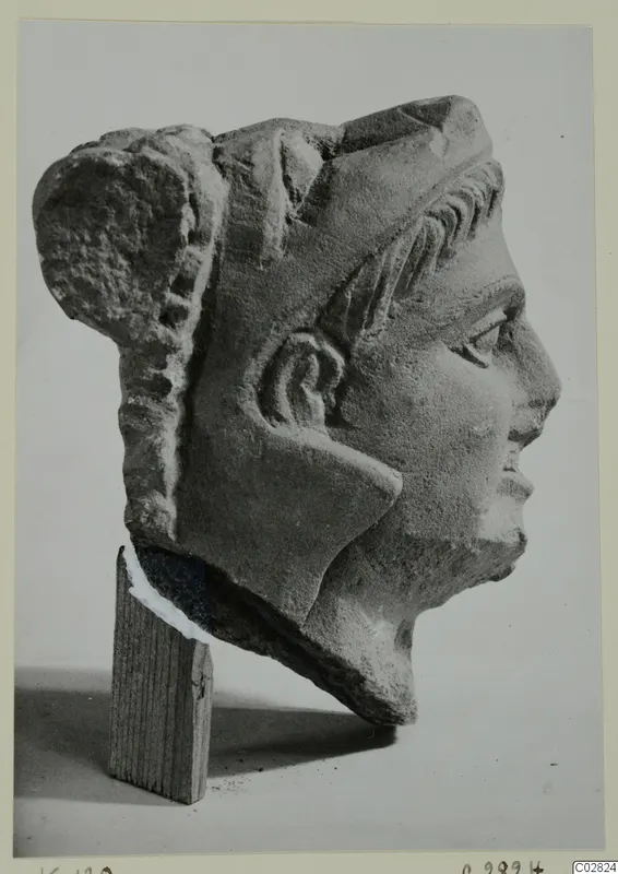 Carved stone head in profile facing right, from Kition, shown on a wooden block