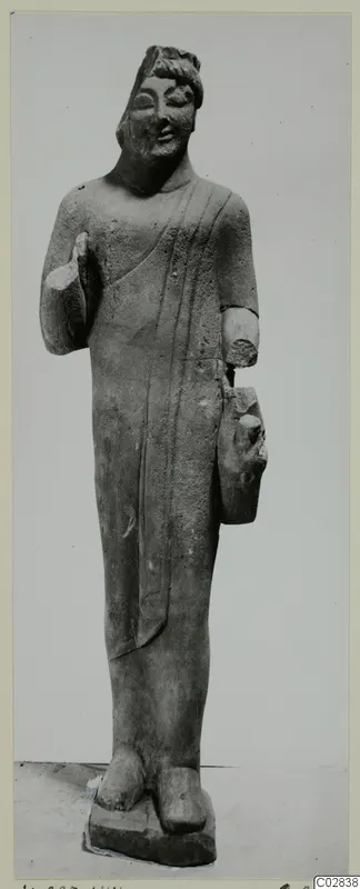 Limestone statue of a standing figure in a long draped garment, from Kition, with broken arms.