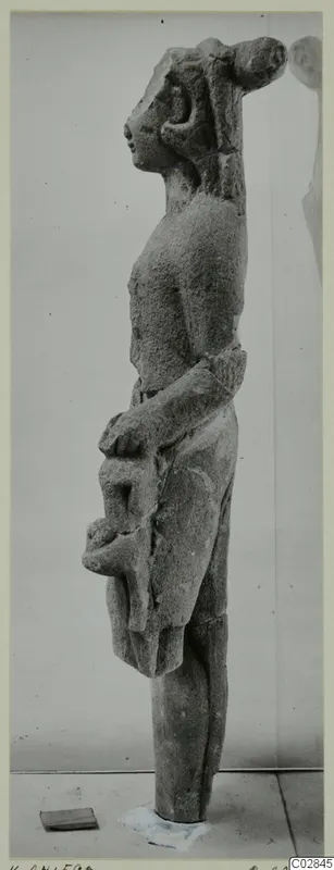 Limestone statue of a standing figure seen in profile, with a tall headdress, from Kition