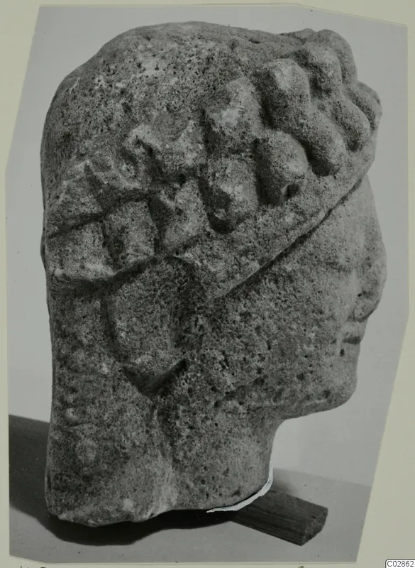Limestone head fragment from Kition, in profile facing right, with rows of curled hair and a band across the head.