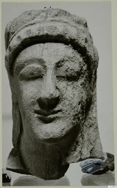 Limestone head from Kition with downcast eyes and a close-fitting headdress, neck broken off