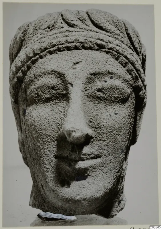 Limestone head fragment from Kition, face with heavy eyelids, broken nose and banded headdress