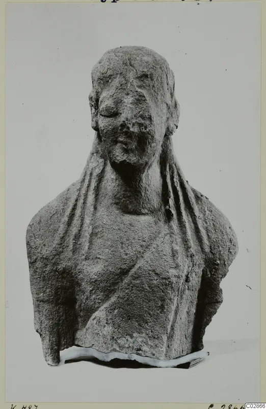 Limestone bust fragment from Kition, head and shoulders draped in a veil, face worn and nose damaged.