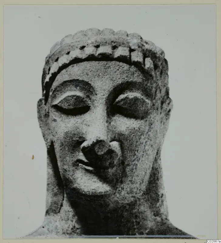 Limestone head statue from Kition, seen front-on with lowered eyes and hair held by a band