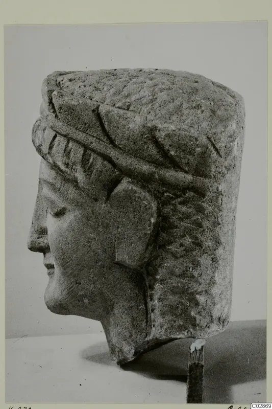 Limestone head from Kition, shown in profile facing left, with a tall cylindrical headdress.