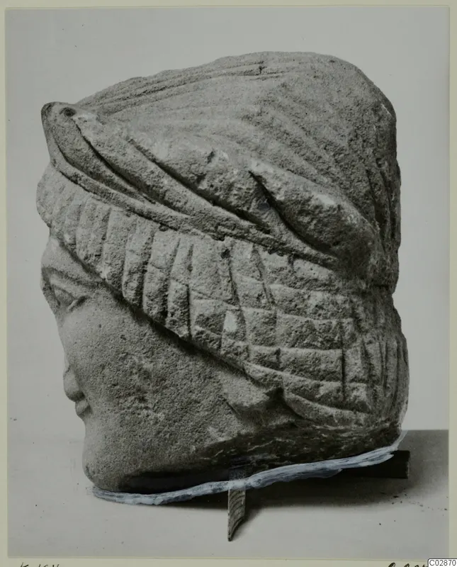 Limestone head of a statuette from Kition, wearing a wrapped headdress with ribbed bands